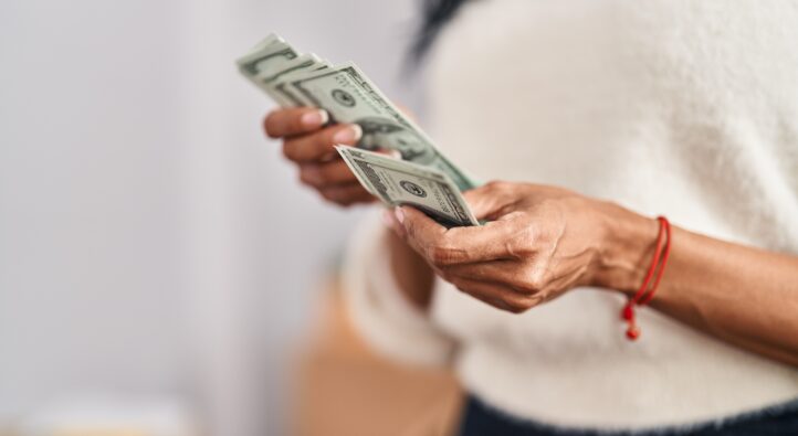 African american woman counting dollars at new home